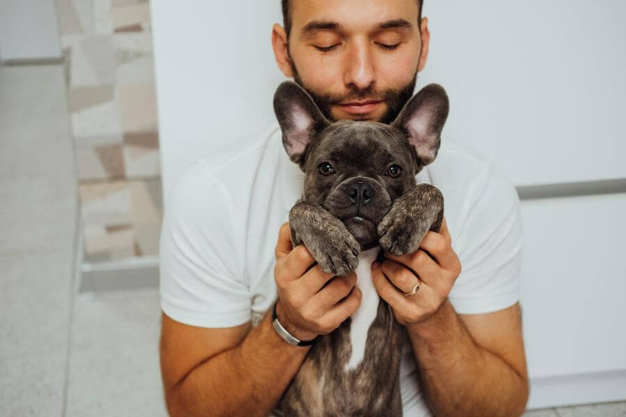 47978356 happy caucasian man hugging his lovely pet french bulldog